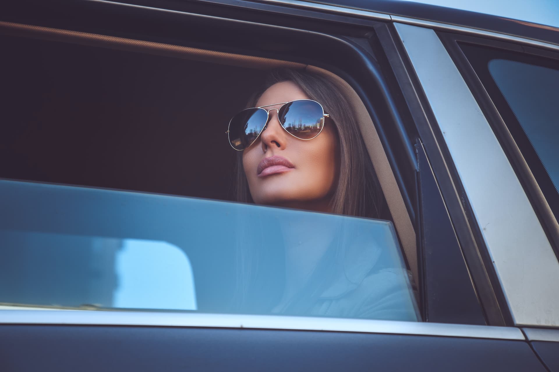 A passenger riding in the back of a chauffeured car